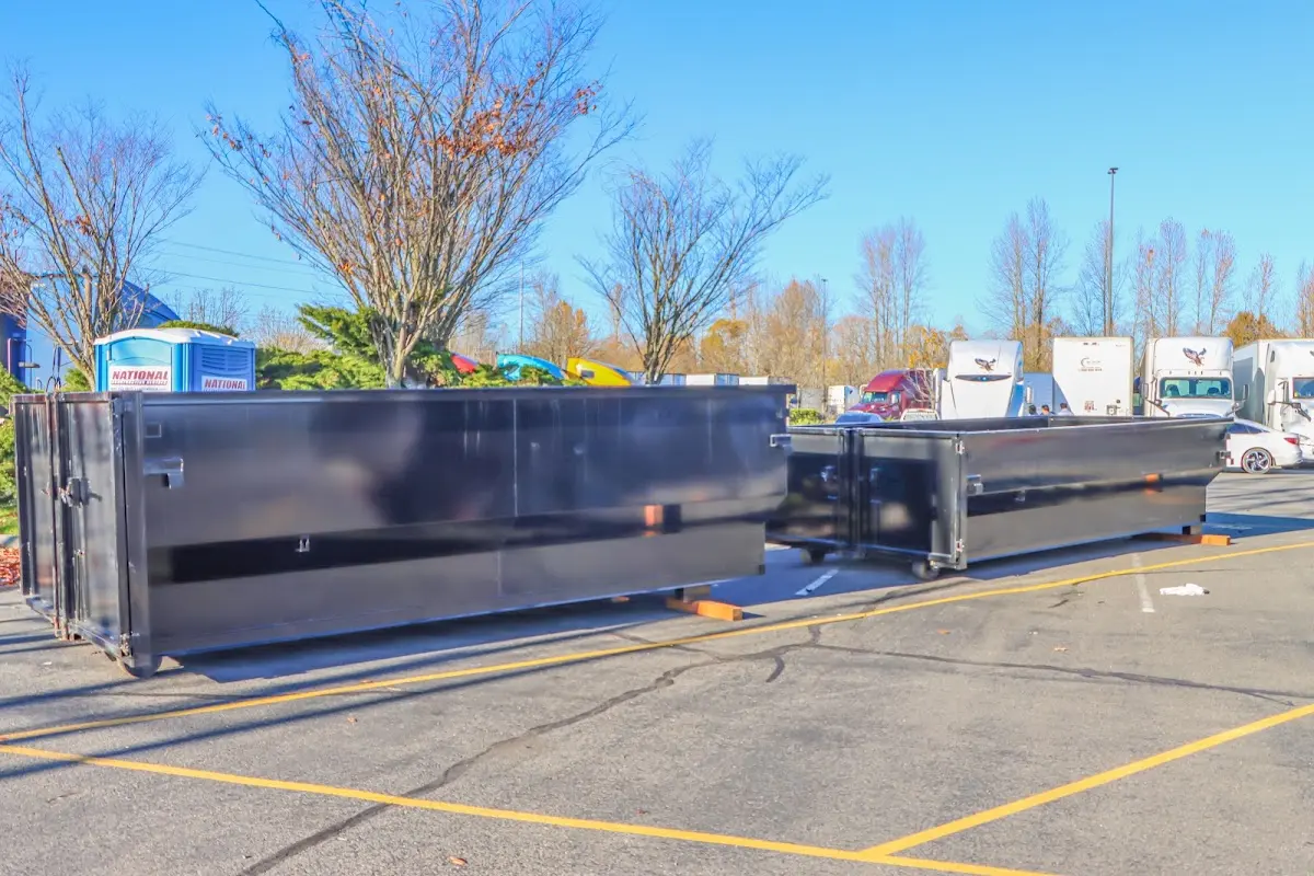 Professional dumpster rental service with roll-off container on residential driveway in Barre